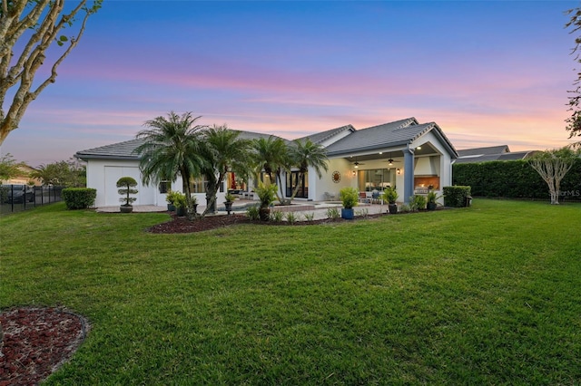 back of property with a tiled roof, ceiling fan, fence, a patio, and stucco siding