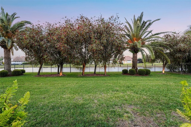view of yard featuring fence and a water view