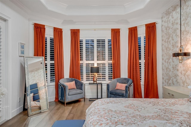 bedroom featuring crown molding, a raised ceiling, and wood finished floors