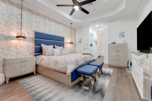 bedroom featuring visible vents, a tray ceiling, crown molding, and wood finished floors
