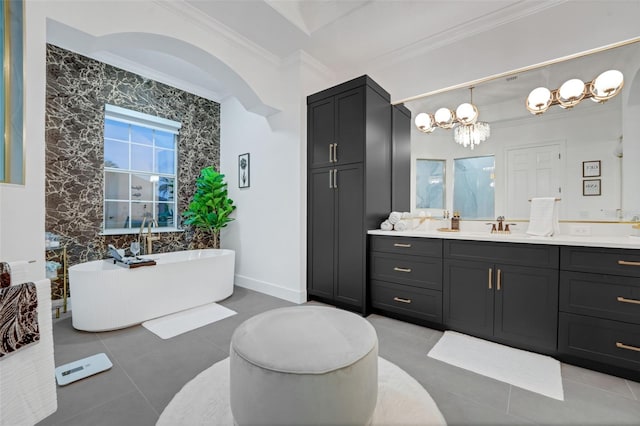 full bathroom featuring a notable chandelier, a soaking tub, crown molding, vanity, and tile patterned flooring