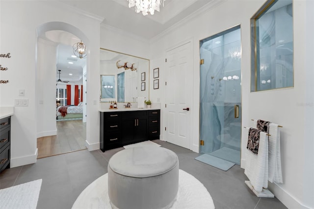 ensuite bathroom with vanity, a stall shower, ensuite bath, crown molding, and ceiling fan with notable chandelier