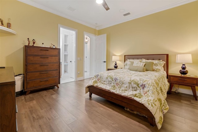bedroom featuring crown molding, wood finished floors, and visible vents