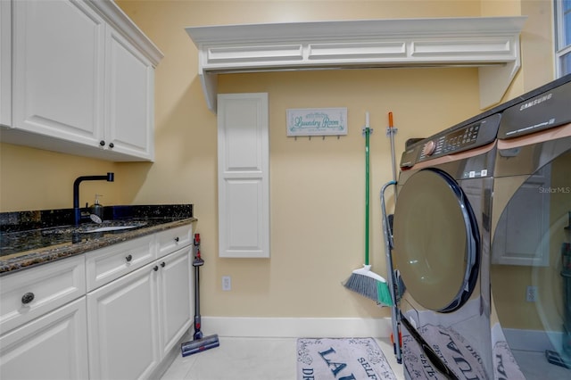 laundry room featuring washer / clothes dryer, baseboards, tile patterned floors, cabinet space, and a sink