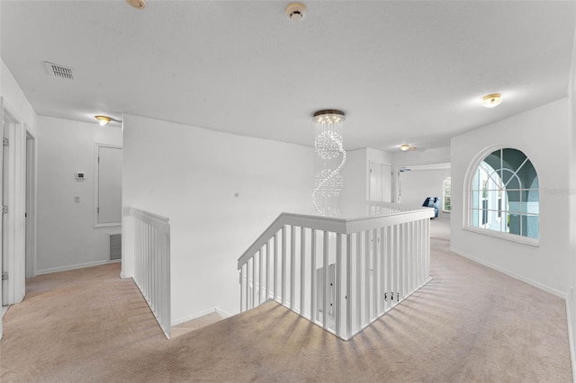 219 Strathmore Cir, Kissimmee, FL 34744 - hallway with baseboards, visible vents, carpet floors, and an upstairs landing