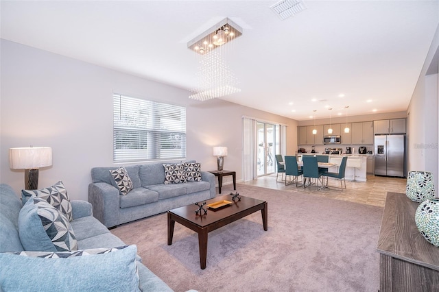 living area featuring light carpet, plenty of natural light, visible vents, and recessed lighting