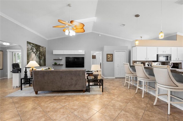 26901 Racquet Cir, Leesburg, FL 34748 - living room with light tile patterned floors, ceiling fan, arched walkways, ornamental molding, and high vaulted ceiling