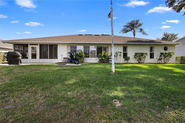 26901 Racquet Cir, Leesburg, FL 34748 - back of house with a shingled roof, stucco siding, a sunroom, and a lawn