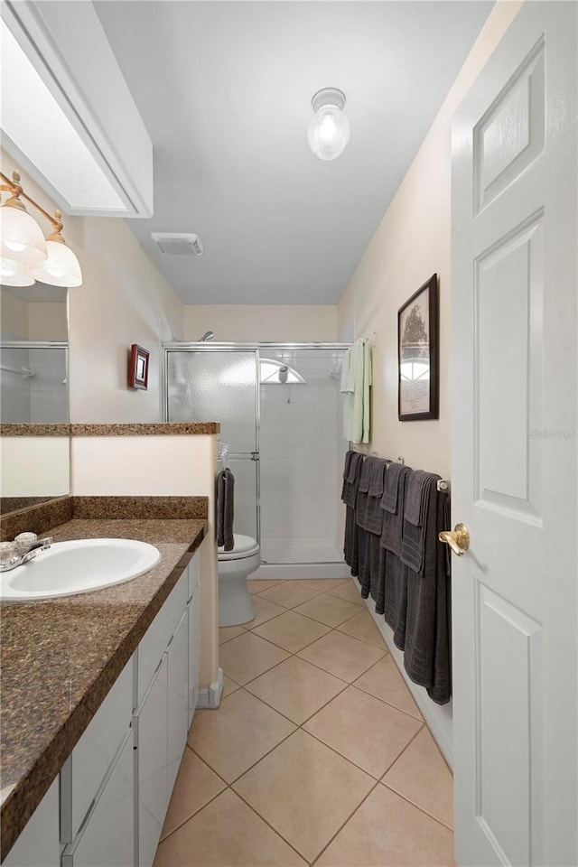 26901 Racquet Cir, Leesburg, FL 34748 - bathroom with tile patterned flooring, toilet, vanity, visible vents, and a stall shower