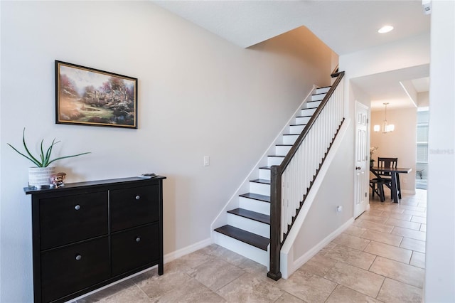 staircase with baseboards and a notable chandelier