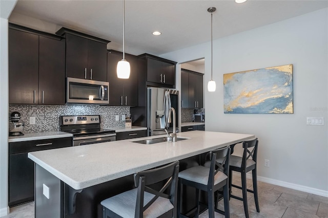 kitchen featuring a sink, a kitchen island with sink, a kitchen bar, and stainless steel appliances
