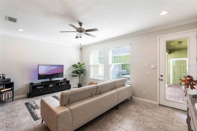 living area with baseboards, ornamental molding, a ceiling fan, and visible vents