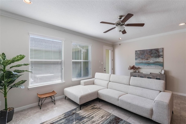 living area with baseboards, ornamental molding, tile patterned floors, and ceiling fan