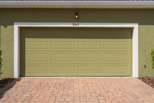garage with decorative driveway