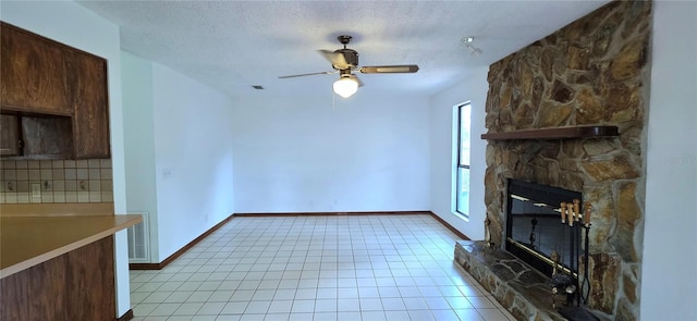 6277 Cranberry Ln W, Jacksonville, FL 32244 - unfurnished living room with ceiling fan, a fireplace, light tile patterned flooring, baseboards, and a textured ceiling