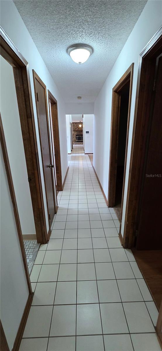 6277 Cranberry Ln W, Jacksonville, FL 32244 - corridor with a textured ceiling and light tile patterned floors