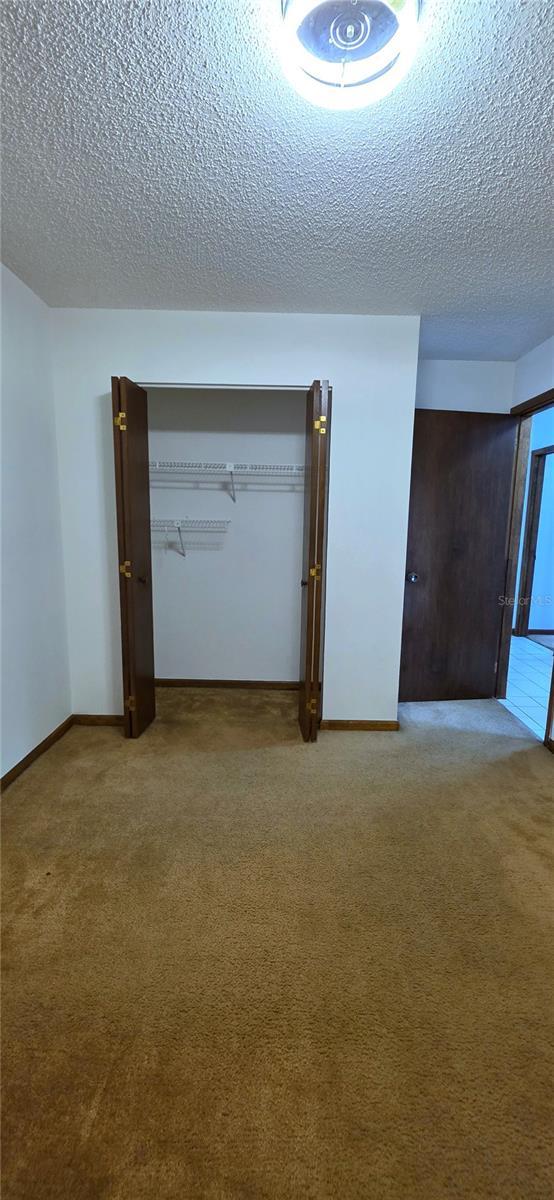 6277 Cranberry Ln W, Jacksonville, FL 32244 - carpeted spare room featuring a textured ceiling and baseboards