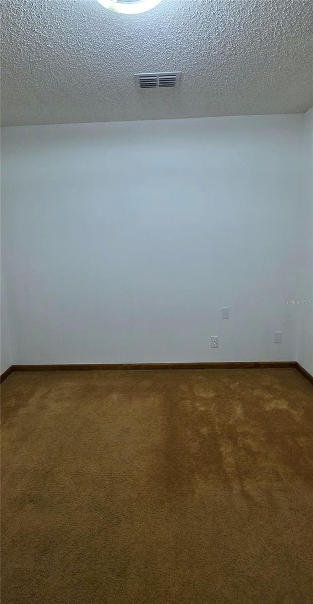 6277 Cranberry Ln W, Jacksonville, FL 32244 - spare room featuring carpet, baseboards, and a textured ceiling
