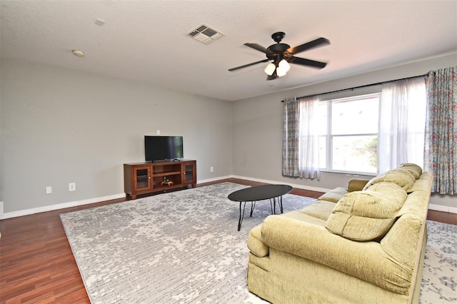 living room with visible vents, baseboards, a ceiling fan, and wood finished floors