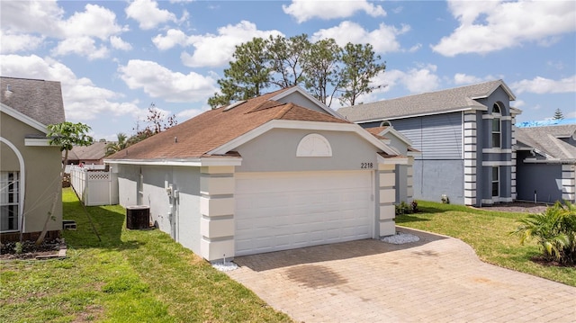 2218 Newt St, Orlando, FL 32837 - ranch-style home featuring a garage, a front yard, decorative driveway, and central air condition unit