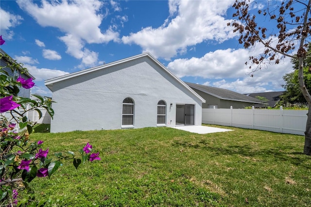 2218 Newt St, Orlando, FL 32837 - rear view of house with a lawn, fence, stucco siding, and a patio area