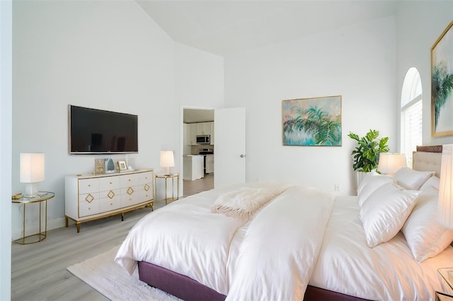 2218 Newt St, Orlando, FL 32837 - bedroom with high vaulted ceiling, wood finished floors, and baseboards