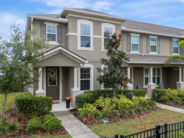 9433 Randal Park Blvd, Orlando, FL 32832 - view of front of home with fence, a shingled roof, and stucco siding
