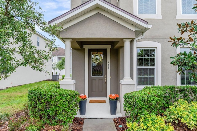 9433 Randal Park Blvd, Orlando, FL 32832 - view of exterior entry featuring stucco siding and central AC