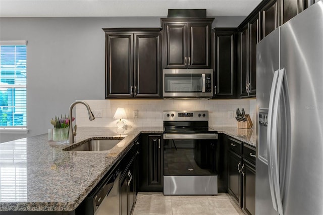 9433 Randal Park Blvd, Orlando, FL 32832 - kitchen featuring a sink, decorative backsplash, light stone counters, and stainless steel appliances
