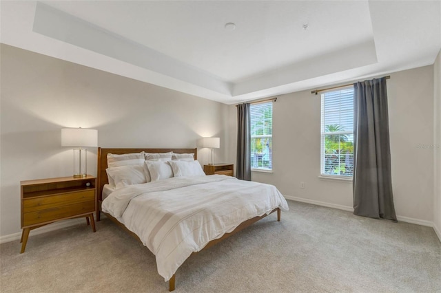 9433 Randal Park Blvd, Orlando, FL 32832 - bedroom featuring a tray ceiling, light carpet, and baseboards