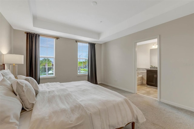 9433 Randal Park Blvd, Orlando, FL 32832 - bedroom featuring ensuite bath, light colored carpet, baseboards, and a raised ceiling