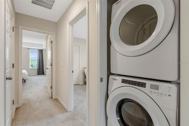 9433 Randal Park Blvd, Orlando, FL 32832 - laundry room with light carpet, visible vents, stacked washer and dryer, and baseboards