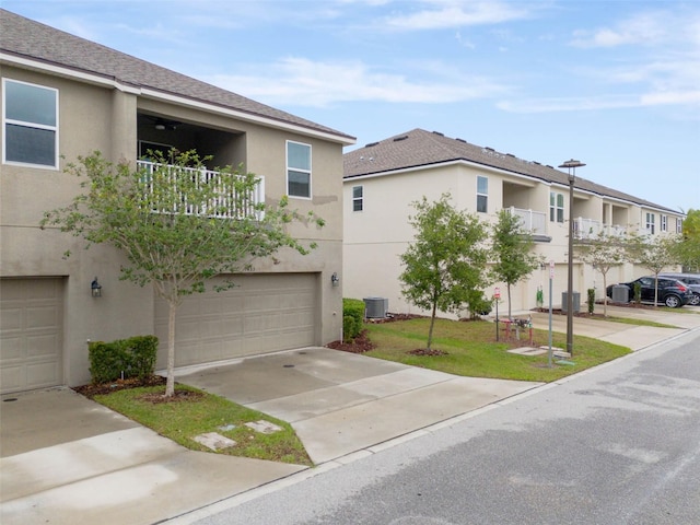 9433 Randal Park Blvd, Orlando, FL 32832 - exterior space featuring cooling unit, stucco siding, a front yard, an attached garage, and concrete driveway