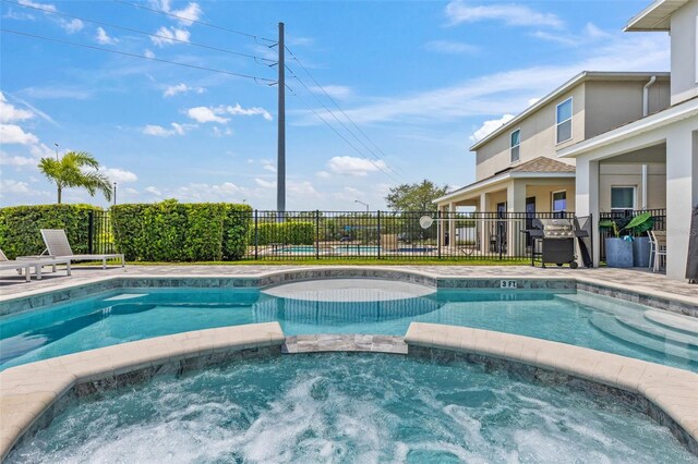 7759 Westland Dr, Kissimmee, FL 34747 - view of pool featuring fence, a pool with connected hot tub, and a grill
