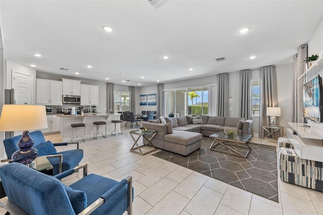 7759 Westland Dr, Kissimmee, FL 34747 - living room with light tile patterned floors, a wealth of natural light, visible vents, and recessed lighting