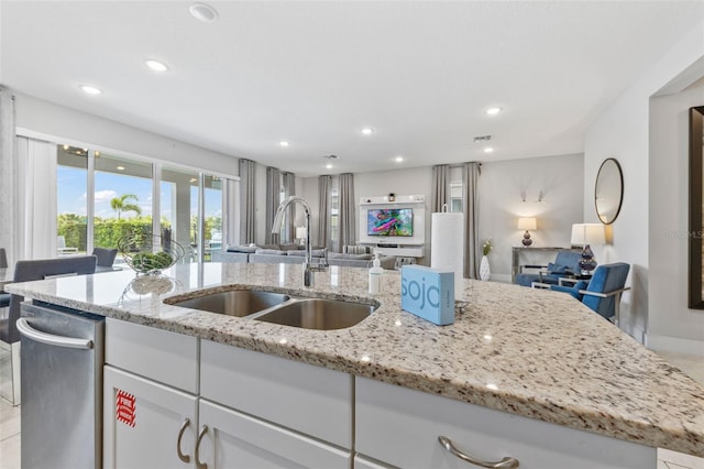 7759 Westland Dr, Kissimmee, FL 34747 - kitchen with open floor plan, light stone countertops, a sink, and white cabinetry