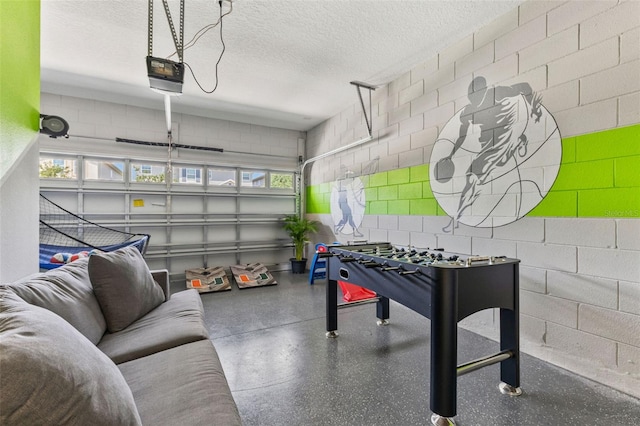7759 Westland Dr, Kissimmee, FL 34747 - recreation room featuring a garage, concrete block wall, and a textured ceiling