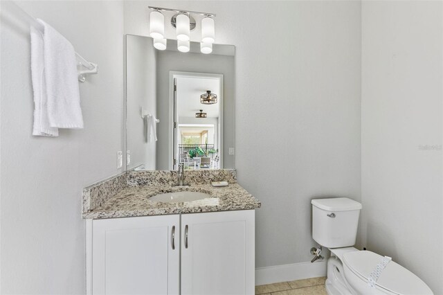 7759 Westland Dr, Kissimmee, FL 34747 - half bath with baseboards, vanity, tile patterned flooring, and toilet