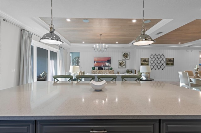 kitchen featuring open floor plan, visible vents, light stone counters, and a raised ceiling