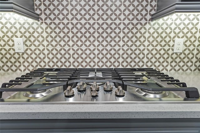 room details featuring light countertops, tasteful backsplash, and stainless steel gas cooktop