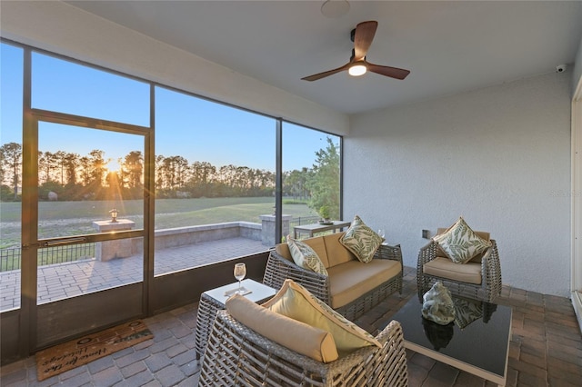 sunroom / solarium with an outdoor hangout area, ceiling fan, and a water view
