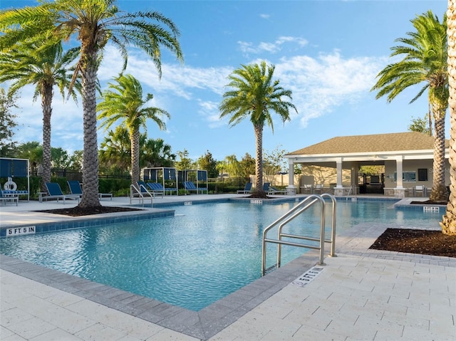 community pool with fence and a patio area