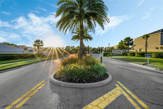 view of road featuring street lights, a residential view, and curbs