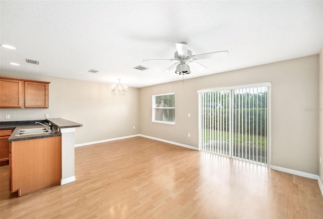 5004 Ashford Falls Ln, Oviedo, FL 32765 - unfurnished living room with ceiling fan, a sink, a chandelier, and light wood-style floors