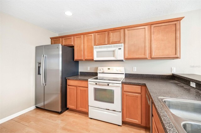 5004 Ashford Falls Ln, Oviedo, FL 32765 - kitchen featuring white appliances, light wood finished floors, dark countertops, a sink, and recessed lighting