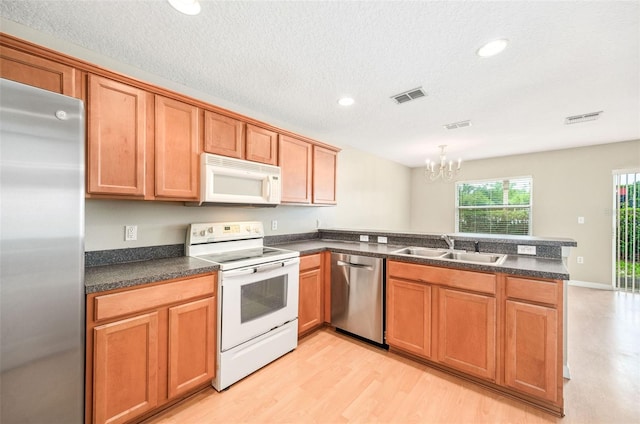 5004 Ashford Falls Ln, Oviedo, FL 32765 - kitchen featuring stainless steel appliances, a sink, a peninsula, a chandelier, and dark countertops