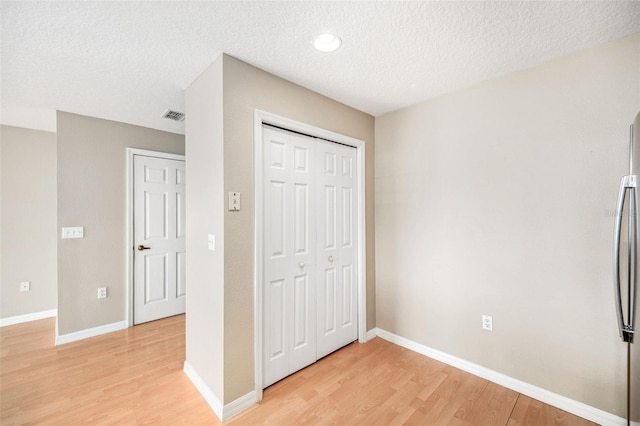 5004 Ashford Falls Ln, Oviedo, FL 32765 - unfurnished bedroom with light wood-type flooring, a textured ceiling, baseboards, and a closet