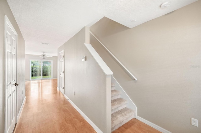 5004 Ashford Falls Ln, Oviedo, FL 32765 - staircase featuring wood finished floors, a textured ceiling, baseboards, and a ceiling fan