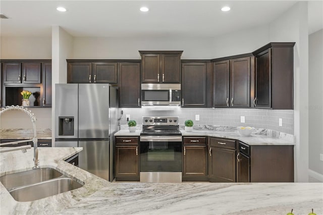 5829 Valentino Way, Lakeland, FL 33812 - kitchen with dark brown cabinets, light stone countertops, appliances with stainless steel finishes, a sink, and tasteful backsplash