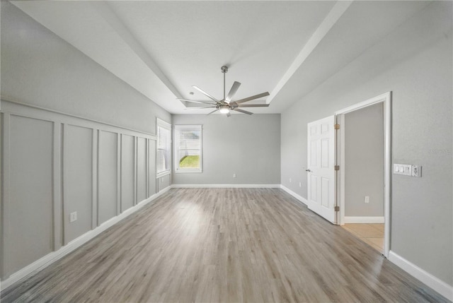 5829 Valentino Way, Lakeland, FL 33812 - unfurnished room featuring baseboards, ceiling fan, wood finished floors, and a raised ceiling